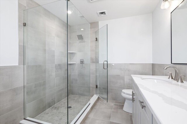 12 Pershing Pl, Island Park, NY 11558 - full bath featuring vanity, a stall shower, tile patterned flooring, and tile walls