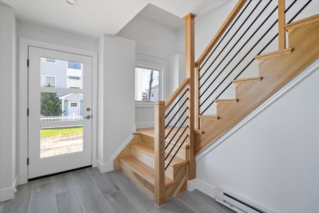 12 Pershing Pl, Island Park, NY 11558 - foyer entrance with baseboard heating, wood finished floors, and stairway