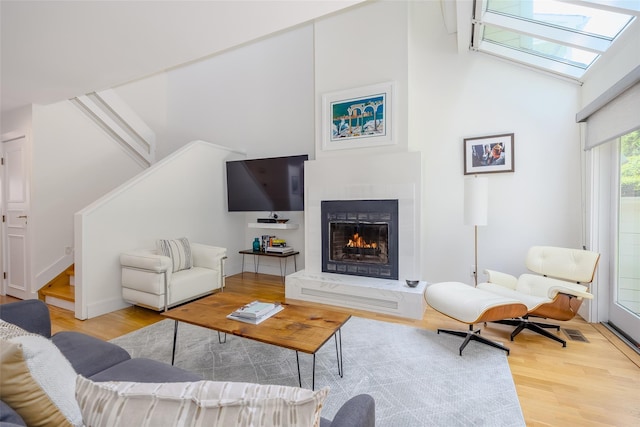 10 Head Of Pond Rd Unit 8, Water Mill, NY 11976 - living room featuring wood finished floors, stairs, a high end fireplace, a skylight, and vaulted ceiling