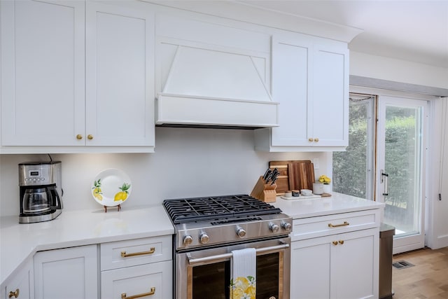 10 Head Of Pond Rd Unit 8, Water Mill, NY 11976 - kitchen with stainless steel gas range oven, premium range hood, white cabinets, light countertops, and light wood-style flooring