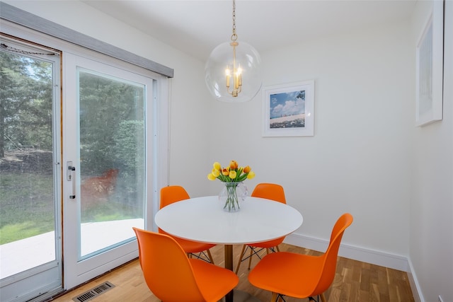 10 Head Of Pond Rd Unit 8, Water Mill, NY 11976 - dining area with a chandelier, wood finished floors, healthy amount of natural light, and baseboards