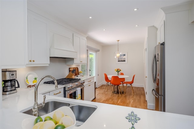 10 Head Of Pond Rd Unit 8, Water Mill, NY 11976 - kitchen with custom range hood, stainless steel appliances, a sink, light countertops, and light wood finished floors
