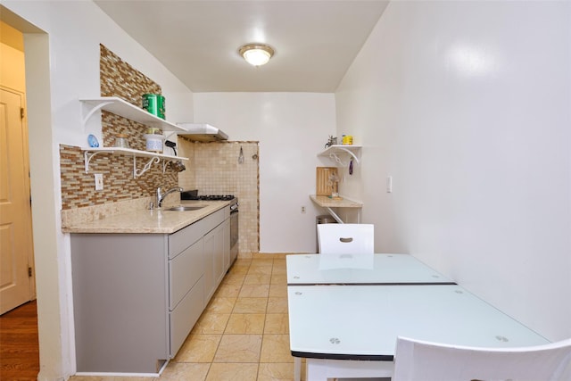 67-25 Clyde St Unit 2L, Forest Hills, NY 11375 - kitchen with open shelves, stainless steel gas range oven, a sink, light countertops, and backsplash