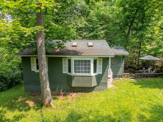 9 Higgins Trl, Monroe, NY 10950 - view of front facade featuring a front yard, a shingled roof, and an outdoor structure