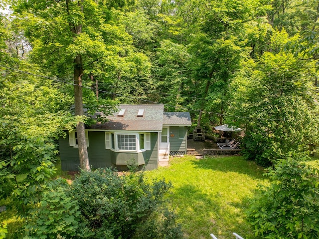 9 Higgins Trl, Monroe, NY 10950 - rear view of property featuring a shingled roof, a lawn, a wooded view, and an outdoor structure