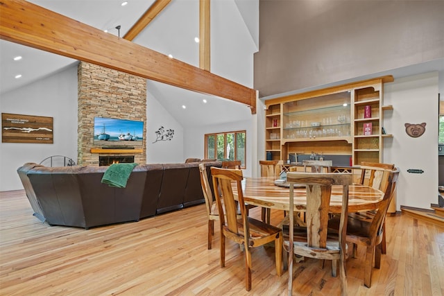 1775 Plank Rd, Forestburgh, NY 12777 - dining area featuring high vaulted ceiling, light wood-type flooring, a stone fireplace, beamed ceiling, and recessed lighting