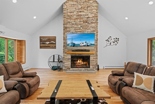 1775 Plank Rd, Forestburgh, NY 12777 - living room with high vaulted ceiling, a baseboard heating unit, a stone fireplace, healthy amount of natural light, and wood finished floors