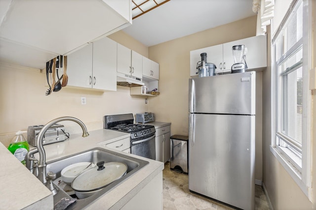 5801 59th St, Maspeth, NY 11378 - kitchen featuring appliances with stainless steel finishes, under cabinet range hood, a sink, light countertops, and white cabinets