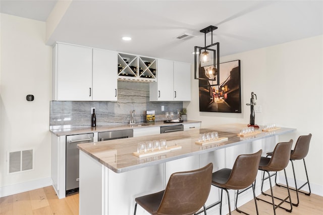 3502 Bennington Dr Unit 113, Fishkill, NY 12524 - kitchen featuring a kitchen bar, tasteful backsplash, light wood-type flooring, baseboards, and recessed lighting