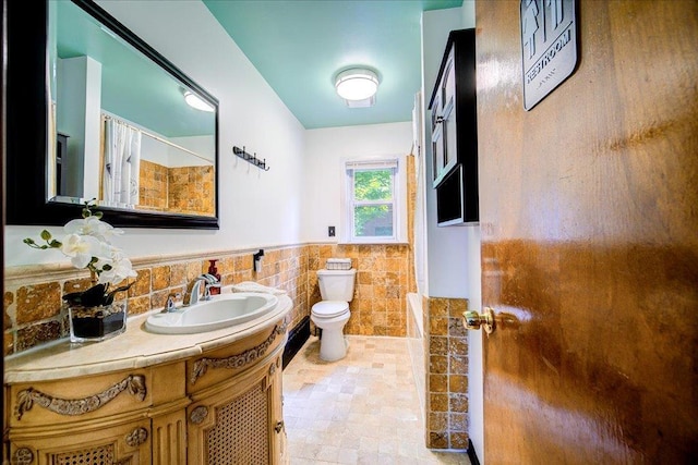 18 Gerow Ln, Cornwall, NY 12553 - bathroom featuring toilet, vanity, curtained shower, a wainscoted wall, and tile walls