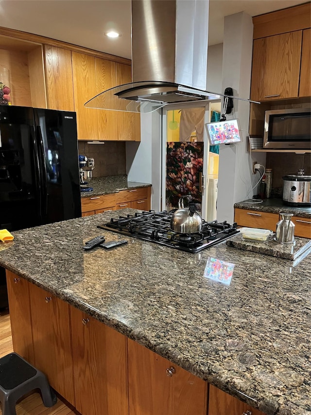 3339 Kingsland Ave, Bronx, NY 10469 - kitchen featuring black appliances, exhaust hood, brown cabinets, dark stone counters, and tasteful backsplash
