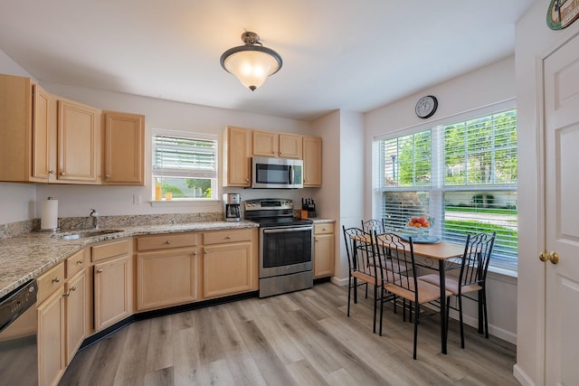 421 Cornwall Meadows Ln, Patterson, NY 12563 - kitchen featuring stainless steel appliances, light brown cabinetry, light wood-style flooring, a sink, and light stone counters