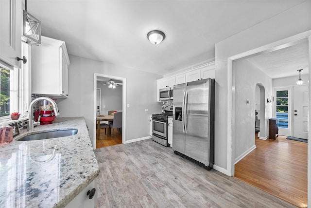 23 Johnson Ln, Millbrook, NY 12545 - kitchen featuring appliances with stainless steel finishes, a ceiling fan, arched walkways, and white cabinetry