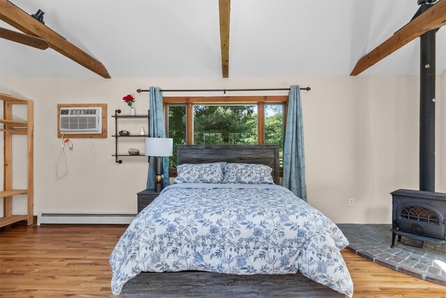 23 Johnson Ln, Millbrook, NY 12545 - bedroom featuring a baseboard radiator, a wall mounted air conditioner, wood finished floors, and a wood stove