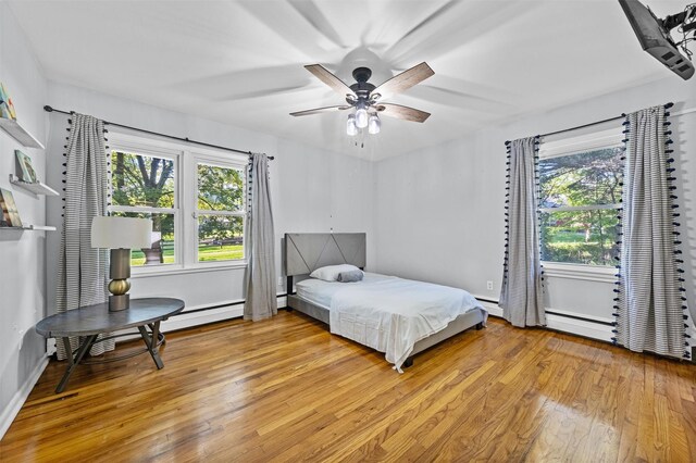 23 Johnson Ln, Millbrook, NY 12545 - bedroom featuring light wood finished floors, multiple windows, a ceiling fan, and a baseboard heating unit