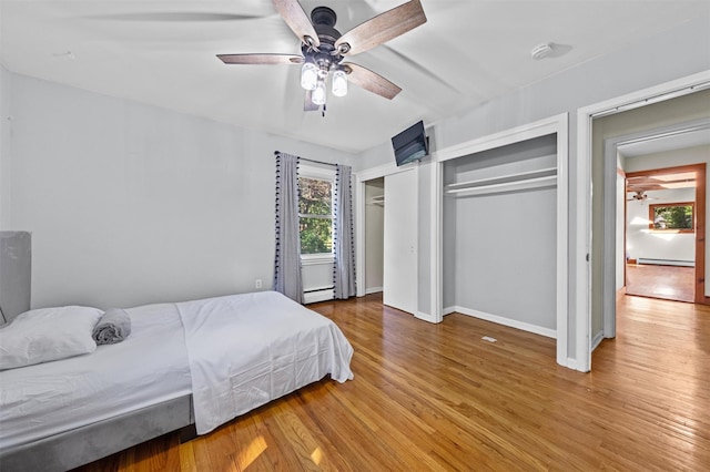 23 Johnson Ln, Millbrook, NY 12545 - bedroom featuring multiple windows, two closets, wood finished floors, and a baseboard radiator