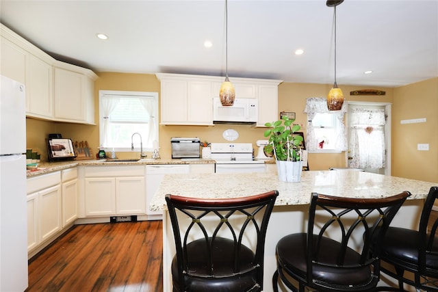 33 Highview Ln, Ridge, NY 11961 - kitchen featuring white appliances, a sink, a kitchen breakfast bar, dark wood-style floors, and hanging light fixtures
