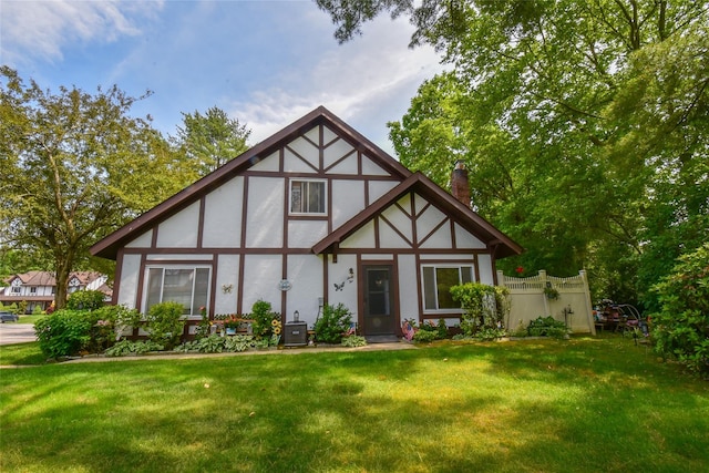 62 Crystal Rock Ct, Middle Island, NY 11953 - tudor-style house featuring stucco siding, a chimney, a front yard, and central AC unit