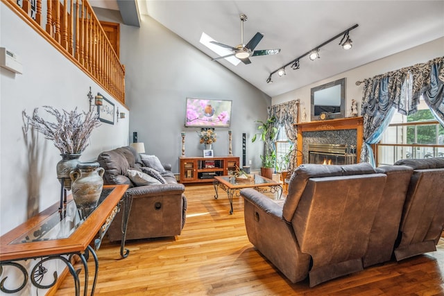 36 Richmond St, Islip, NY 11751 - living area featuring a skylight, light wood finished floors, a ceiling fan, a glass covered fireplace, and high vaulted ceiling