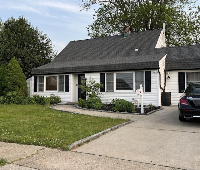 24 Club Ln, Levittown, NY 11756 - view of front of property featuring a front lawn, a shingled roof, concrete driveway, and a chimney