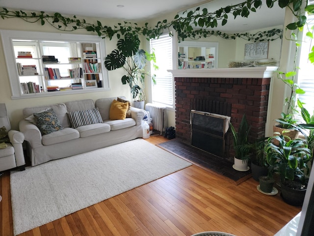 4360 Auburndale Ln, Flushing, NY 11358 - living room with radiator heating unit, wood finished floors, and a brick fireplace