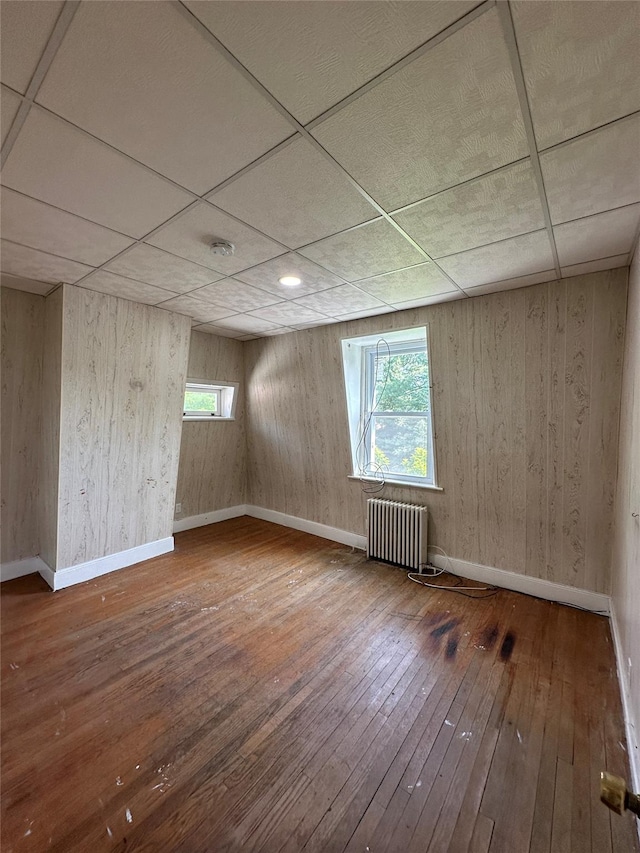 86 S Hamilton St, Poughkeepsie, NY 12601 - empty room featuring radiator heating unit, hardwood / wood-style floors, plenty of natural light, baseboards, and a drop ceiling