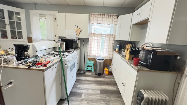 86 S Hamilton St, Poughkeepsie, NY 12601 - kitchen featuring white range with gas cooktop, black microwave, plenty of natural light, white cabinetry, and a drop ceiling