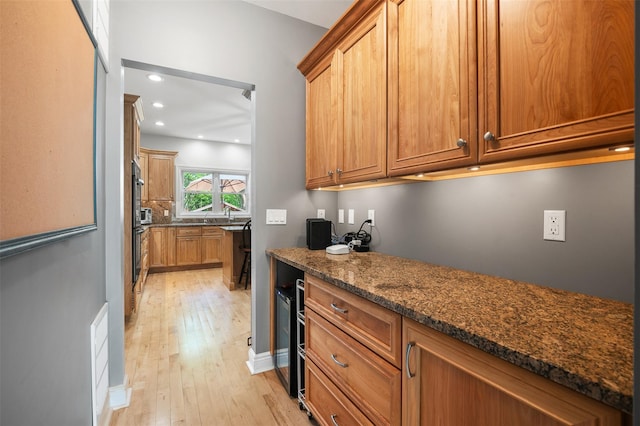 446 M And M Rd, Middletown, NY 10940 - kitchen with light wood-style flooring, dark stone countertops, brown cabinets, recessed lighting, and black oven