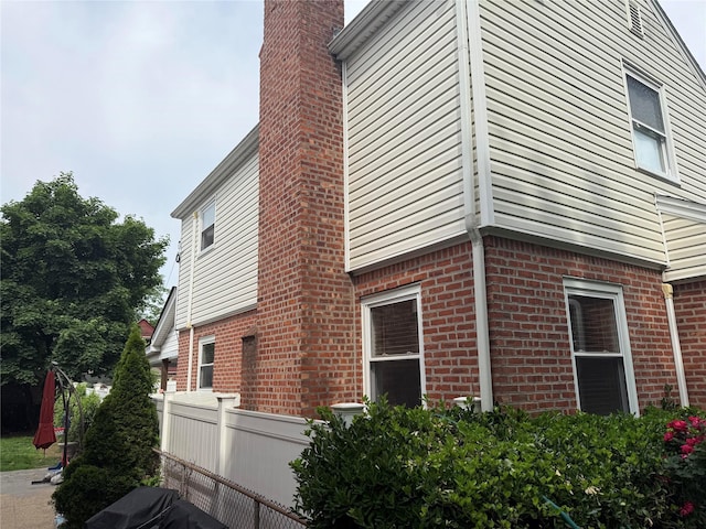 7308 187th St, Fresh Meadows, NY 11366 - view of property exterior with brick siding and a chimney