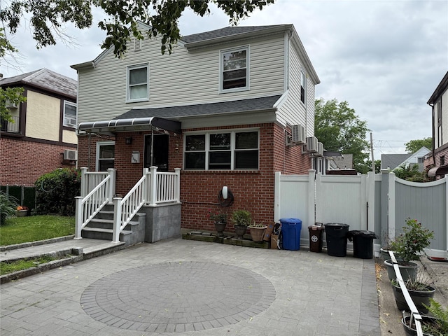 7308 187th St, Fresh Meadows, NY 11366 - view of front of home with brick siding, a patio, and roof with shingles