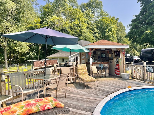 421 Orchard Dr, Wallkill, NY 12589 - wooden terrace with view of wooded area, outdoor dining space, and an outdoor pool