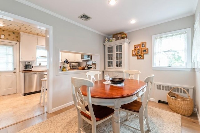 12 Hazel Pl, Woodmere, NY 11598 - dining space featuring radiator, light wood-style floors, and crown molding