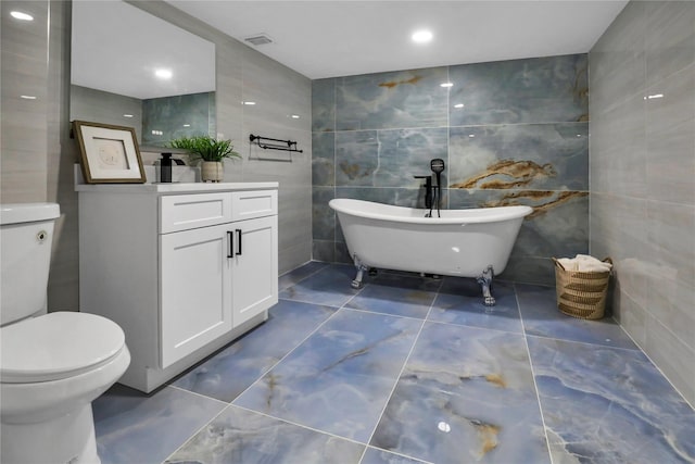 236 Martin Dr, Syosset, NY 11791 - bathroom with tile walls, a soaking tub, toilet, vanity, and tile patterned flooring
