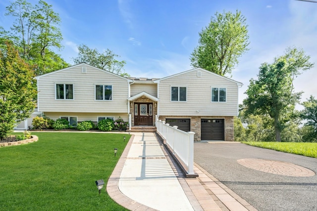 68 Manchester Rd, Huntington, NY 11743 - raised ranch featuring asphalt driveway, an attached garage, a front yard, and stone siding