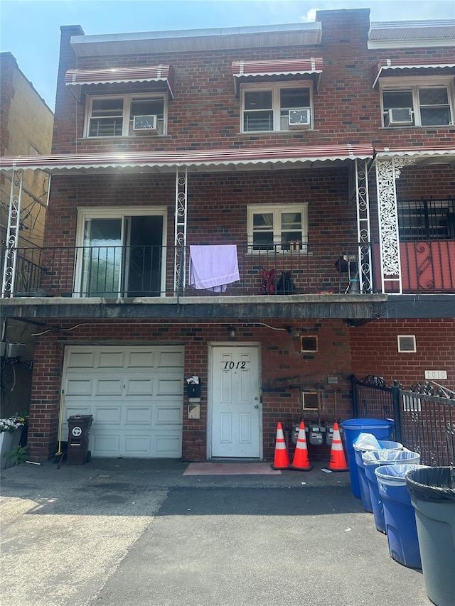 1012 E 233rd St, Bronx, NY 10466 - view of front of property with brick siding, a balcony, a garage, and driveway