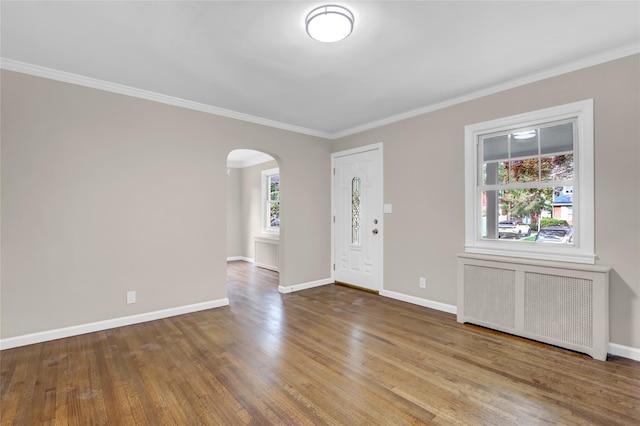 1459 Prince St, Baldwin, NY 11510 - foyer featuring radiator, arched walkways, wood finished floors, ornamental molding, and baseboards
