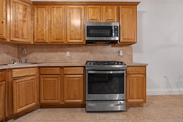 218 Middleton St Unit Apt6Rooftop, Brooklyn, NY 11206 - kitchen featuring appliances with stainless steel finishes, a sink, brown cabinets, light countertops, and backsplash