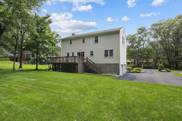 16 Shipley Dr, Cortlandt Manor, NY 10567 - back of property with stairs, a wooden deck, a garage, a lawn, and asphalt driveway