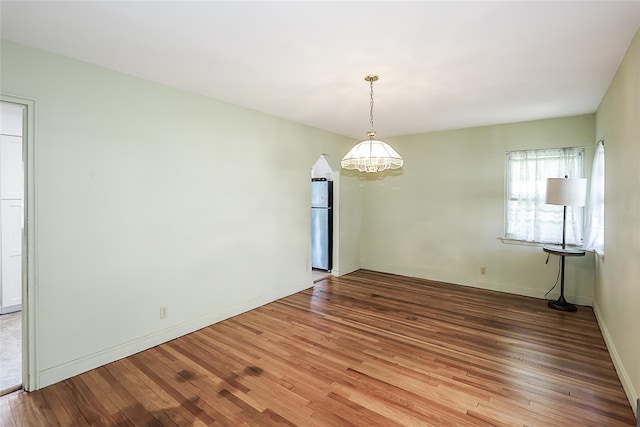 99 Roosevelt Ct, Carle Place, NY 11514 - spare room with wood finished floors, a chandelier, and baseboards