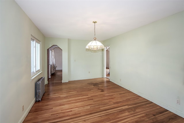 99 Roosevelt Ct, Carle Place, NY 11514 - unfurnished dining area with radiator heating unit, a chandelier, light wood finished floors, baseboards, and arched walkways