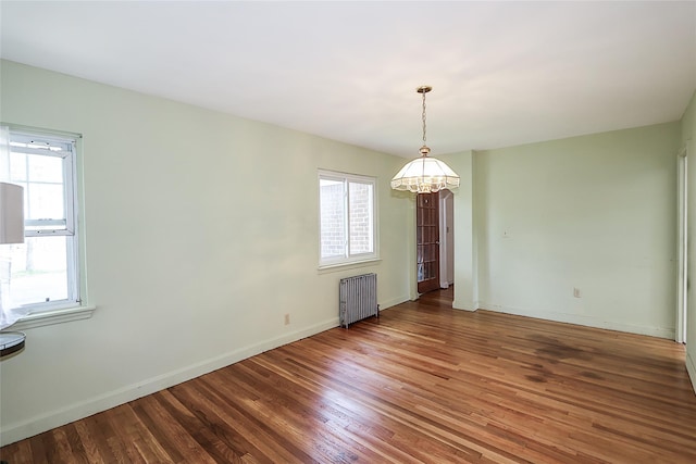 99 Roosevelt Ct, Carle Place, NY 11514 - spare room with radiator, a chandelier, wood finished floors, and baseboards