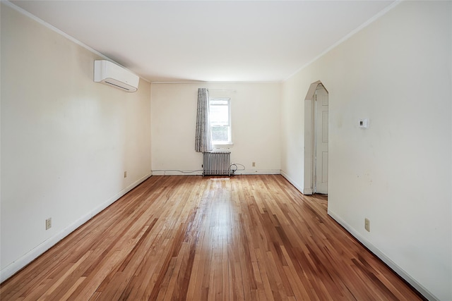99 Roosevelt Ct, Carle Place, NY 11514 - unfurnished room with radiator, a wall mounted AC, ornamental molding, light wood-style floors, and baseboards
