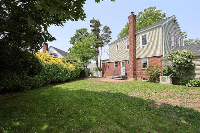 99 Roosevelt Ct, Carle Place, NY 11514 - back of property featuring a chimney, a yard, ac unit, and brick siding