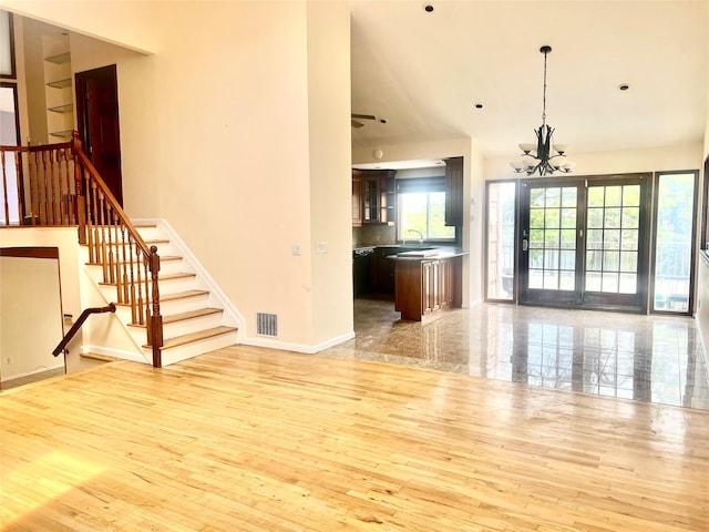 636 Derby Ave, Woodmere, NY 11598 - unfurnished living room featuring stairway, hardwood / wood-style floors, a chandelier, baseboards, and a sink