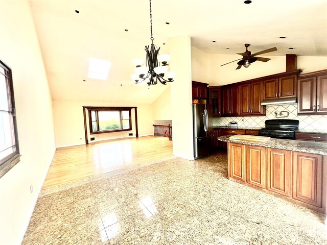 636 Derby Ave, Woodmere, NY 11598 - kitchen with freestanding refrigerator, black stove, under cabinet range hood, baseboards, and open floor plan