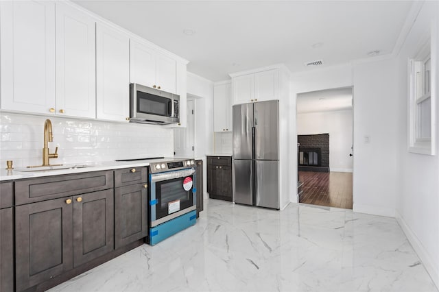 78 Jesse St, Freeport, NY 11520 - kitchen featuring appliances with stainless steel finishes, a sink, decorative backsplash, white cabinets, and light countertops