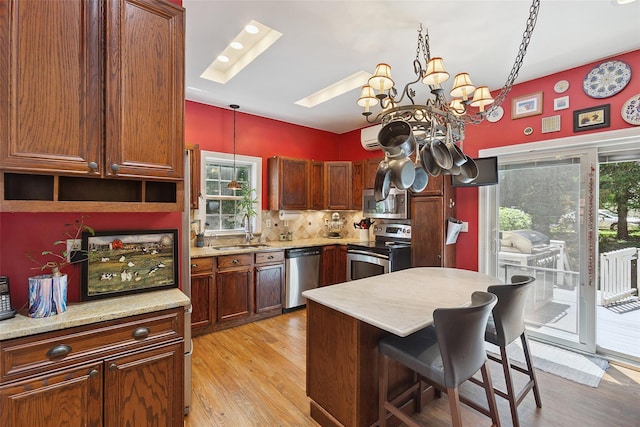 1771 Hanover St, Yorktown Heights, NY 10598 - kitchen featuring stainless steel appliances, a skylight, light wood-style flooring, and a breakfast bar