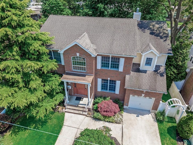 1674 Birch Dr, Merrick, NY 11566 - view of front facade featuring a chimney, brick siding, concrete driveway, and roof with shingles