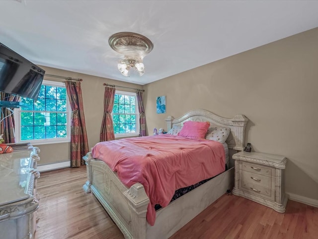 1674 Birch Dr, Merrick, NY 11566 - bedroom with a baseboard heating unit, light wood-style flooring, and baseboards