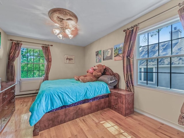 1674 Birch Dr, Merrick, NY 11566 - bedroom featuring wood finished floors and a baseboard heating unit
